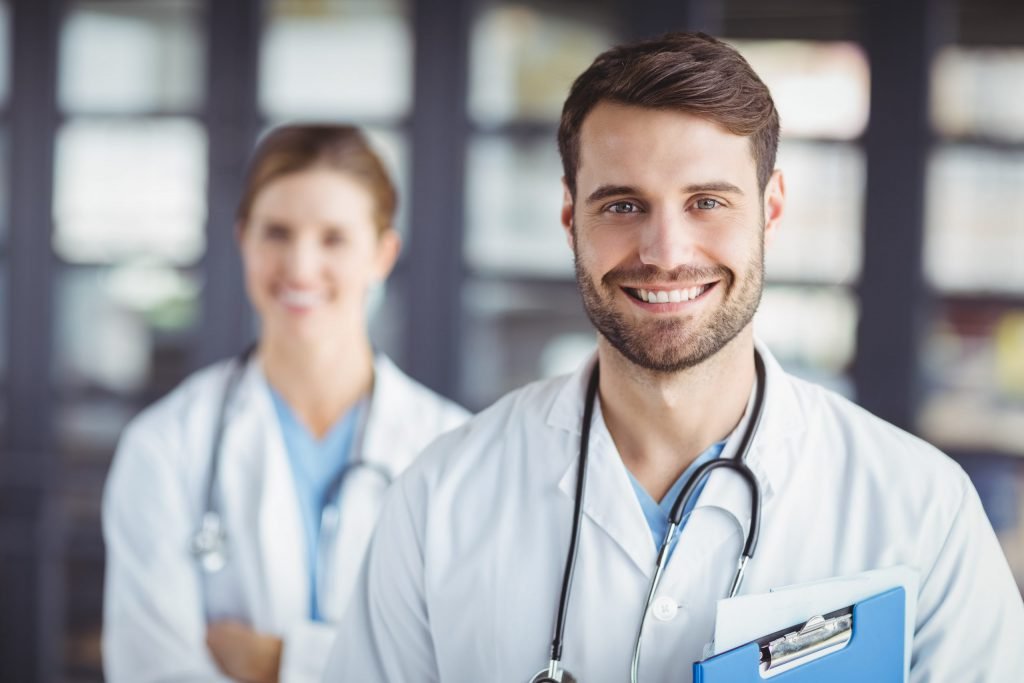 Portrait of happy doctors standing in hospital